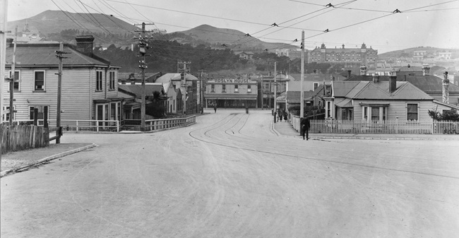 A black and white photo of Donald Street with visible tram tracks on the road and old wooden houses.