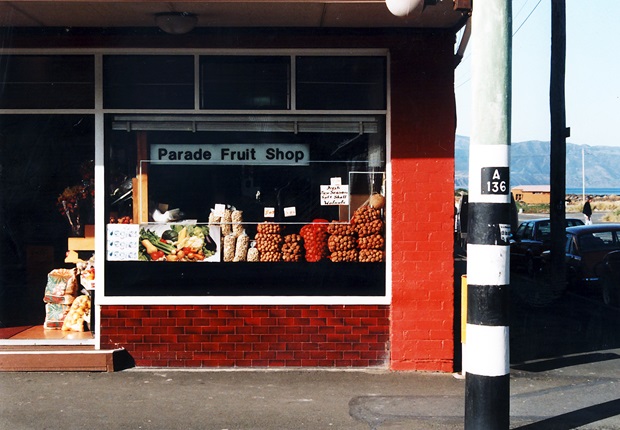 A photo taken in the 1990s of a shop on Island Bay Parade with bags of walnuts in the window and a sign that reads 
