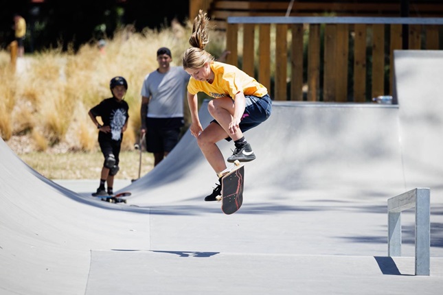 Jessica Wilson performs skate board tricks at a skateboarding park