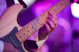 Close up of a guitar and person playing it.
