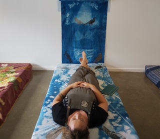 Woman lying on a mattress, staring up at the ceiling.