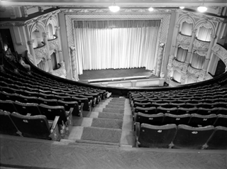 A black and white photo of the seats and stage inside St James Theatre.