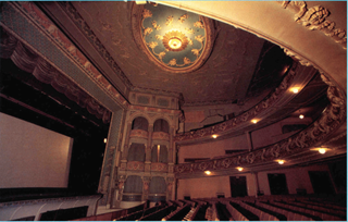 An aged film photograph of the ceiling and chandelier in St James Theatre.