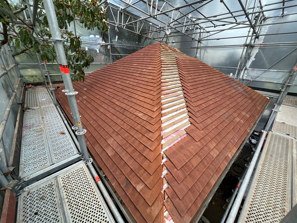 Main Botanic Garden toilet roof tiles being maintained with scaffolding and cladding around it.