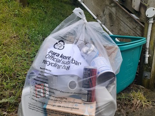 Recycling bag filled with items.