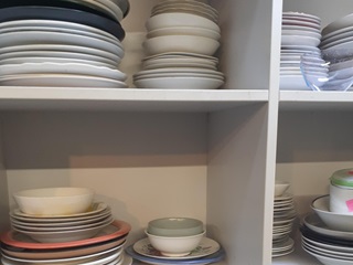 Plates and bowls stacked in a shelf.