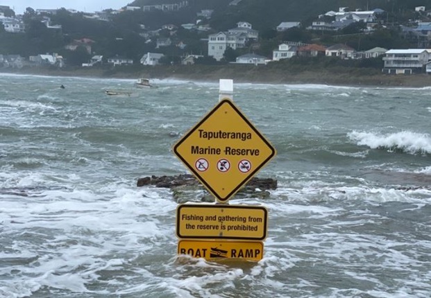 Boat ramp sign in Island Bay under water during heavy storm.