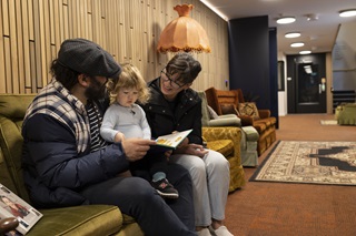 Family of three reading on the couch at the newtown community centre.
