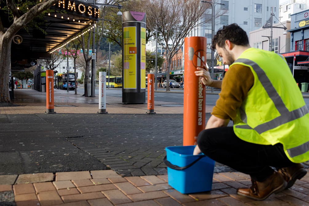 Person scrubbing down bollards.
