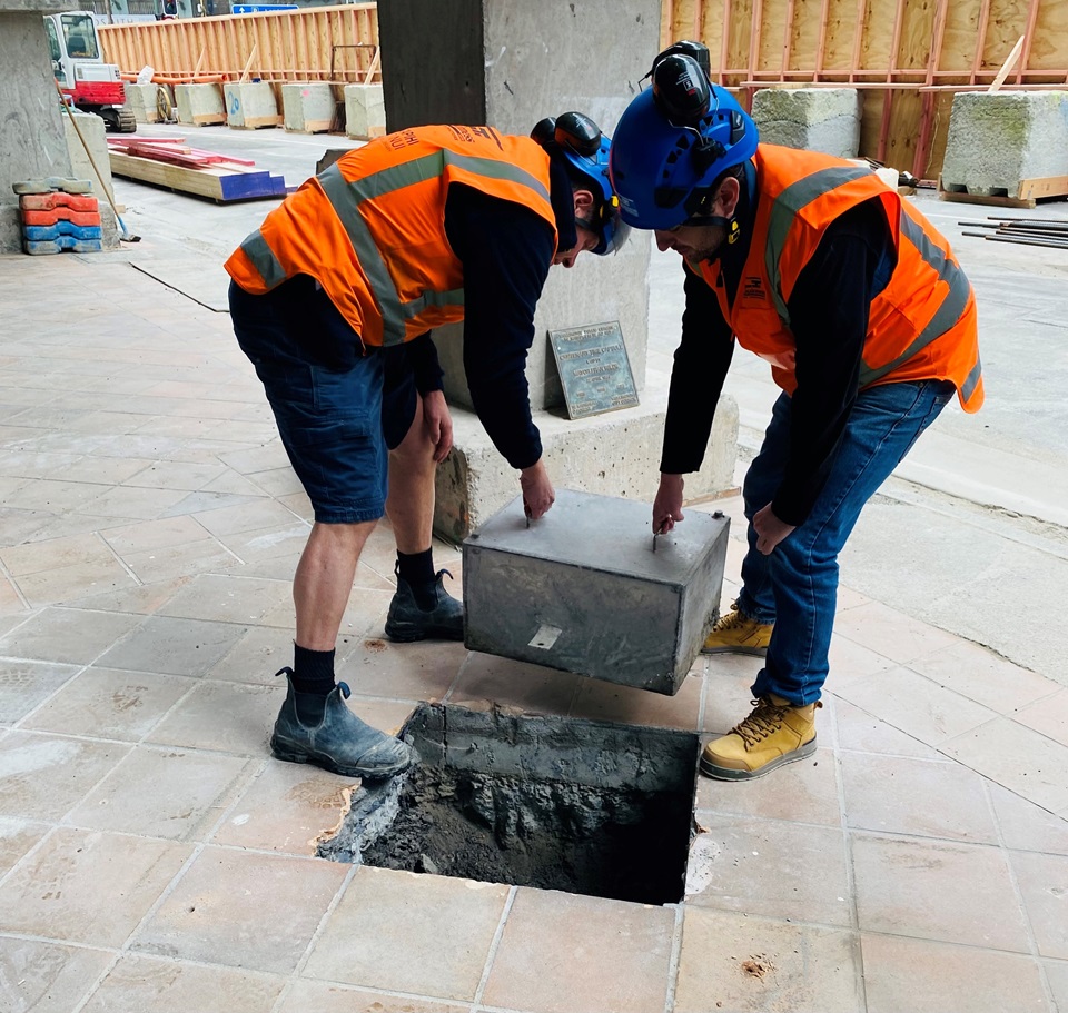Time capsule being removed from buried area at front entrance of site of Central Library Te Matapihi.