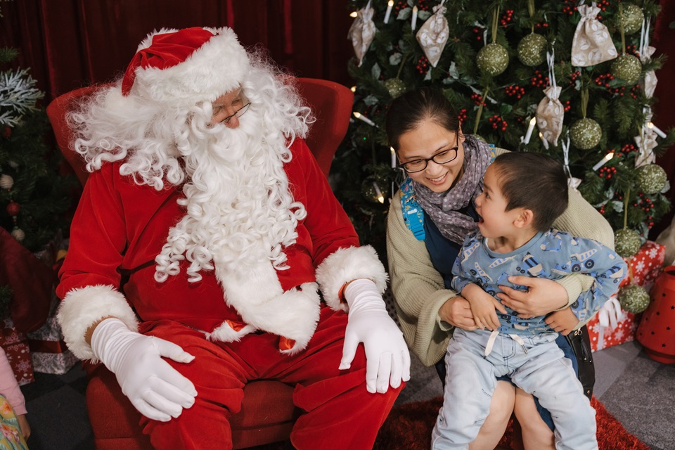 Santa entertains young child in grotto at Christmas event in Wellington