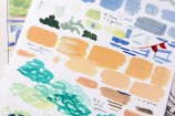 A close-up of a piece of paper with colour swatches painted in watercolour on it.