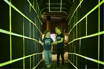 Young people walking through sci fi tunnel at Space Place.