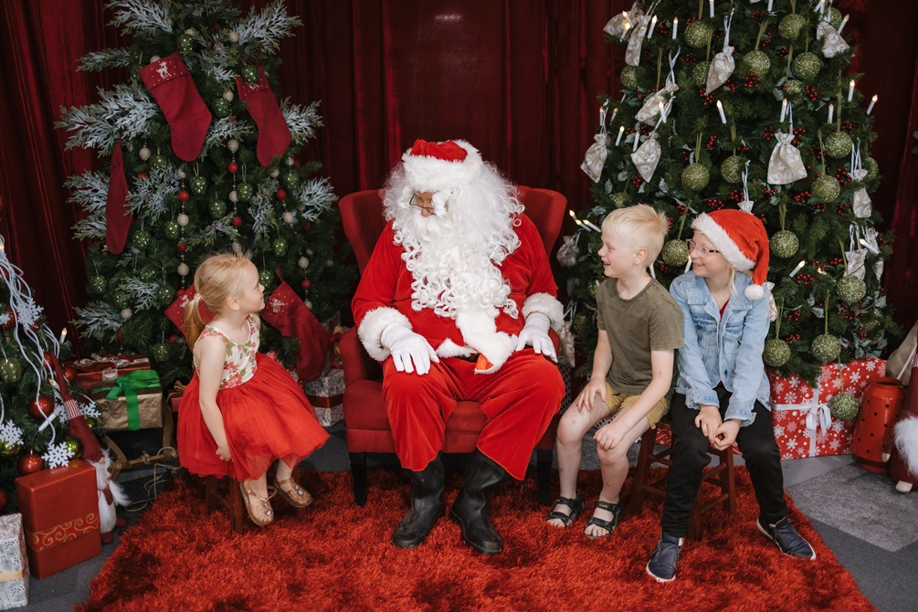 Three kids sitting with Santa.