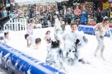 Children playing in a large inflatable pool filled with foam.