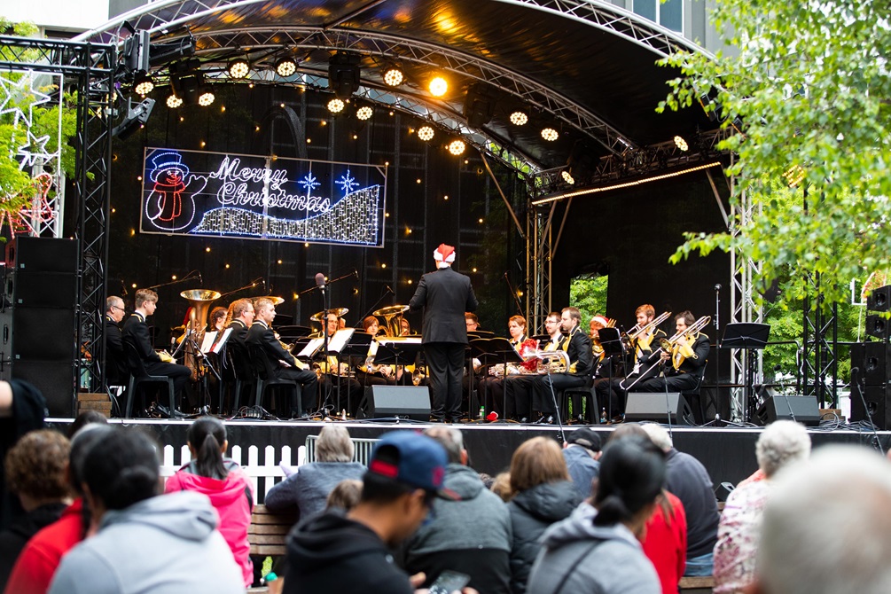 An orchestra performing Christmas carols on a stage.