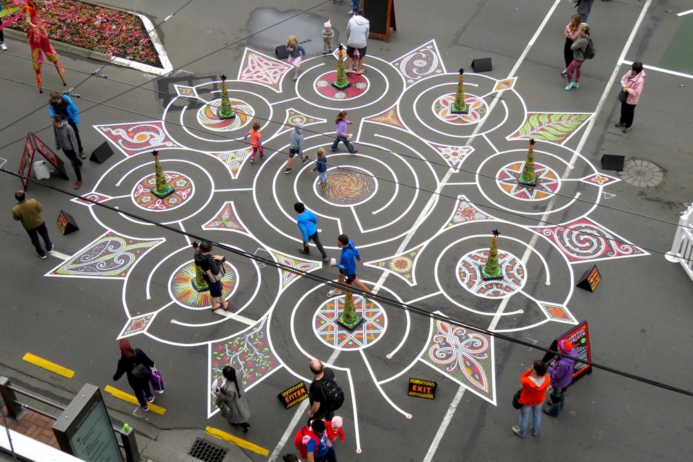 Children and adults walking through a labyrinth design painted on Lambton Quay.