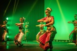 Young people engaging in traditional dance on a stage.