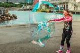A performer creating a huge bubble on the waterfront.