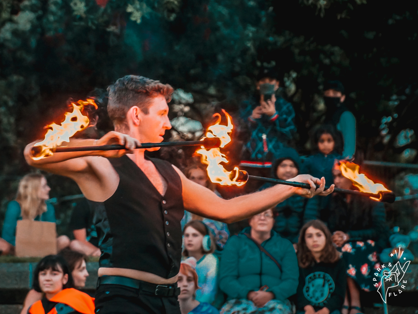 A fire performer in front of a crowd.