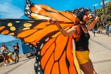 A performer with a giant butterfly cape flying out behind them.