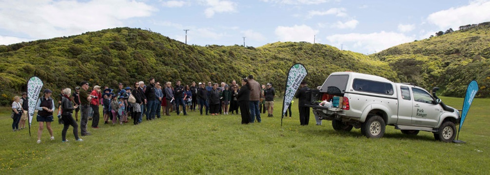 A group of people in a green field attending the opening celebrations for the Te Ara Paparārangi track.