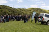 A group of people in a green field attending the opening celebrations for the Te Ara Paparārangi track.
