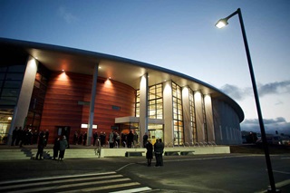 Ākau Tangi Sports Centre at night. 