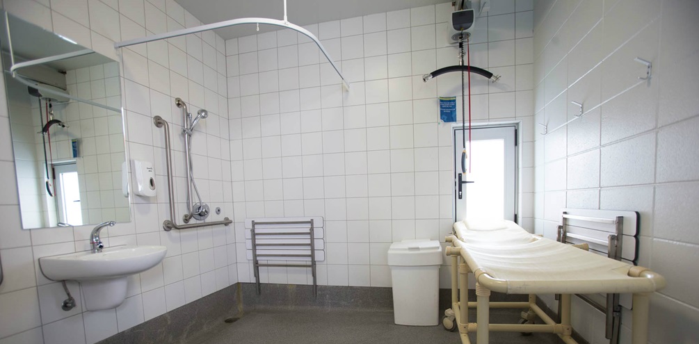 Accessible changing facilities with hoist for pool access