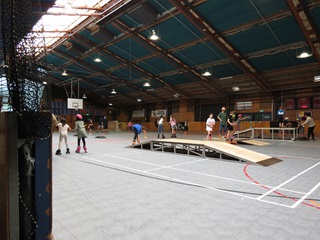People roller blading and skating on Kilbirnie Recreation Centre’s concrete rink with ramps.