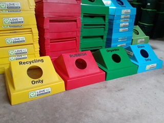 Four hoods for bins in four colours: yellow, red, green and blue.