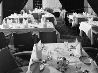 Interior of Le Normandie retaurant, Cuba Street, Wellington, showing table settings and interior decoration. Photographed by K E Niven Ltd some time between 1961 and 1973.
