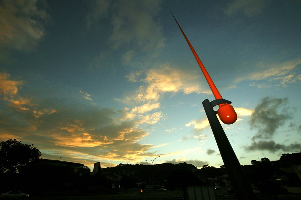 The windwand at sunset, showing the bright orange metal want pointing up towards the sunsetting sky.