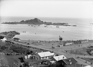 Historic photo of the beach at Island Bay and showing Tapiteranga Island. Taken by Sydney Charles Smith 1888-1972.