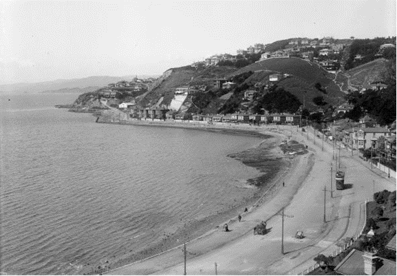 An aerial black and white photo showing Oriental Parade with a Tram line. 